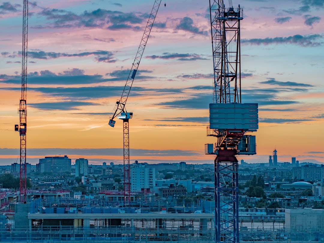 blue and white crane under cloudy sky during daytime