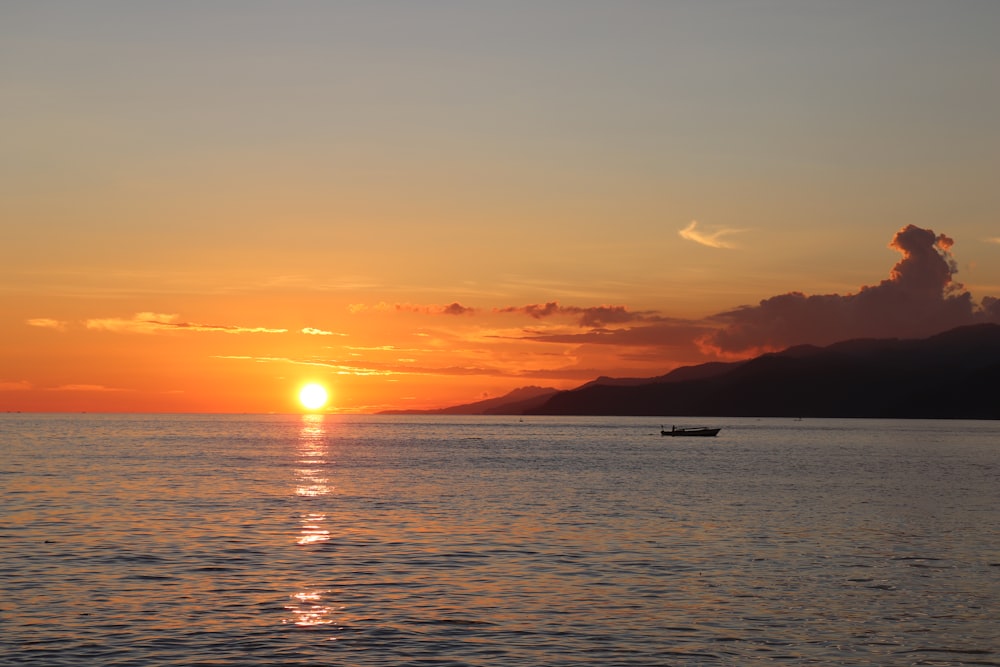 silhouette of boat on sea during sunset