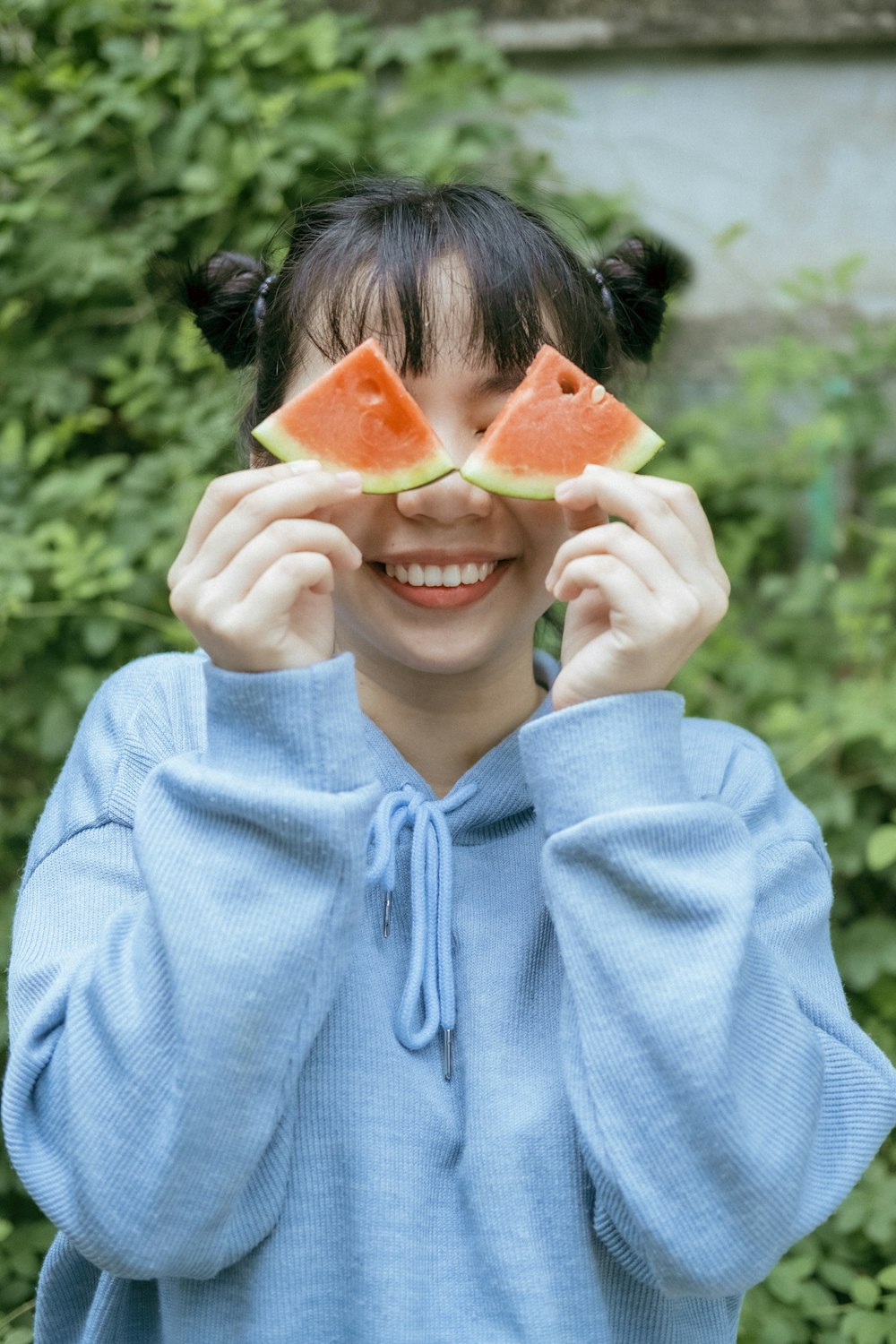 얇게 썬 수박을 들고 있는 파란색 까마귀를 입은 여자