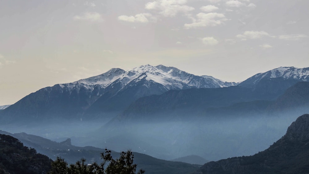 montanha coberta de neve sob céu nublado durante o dia