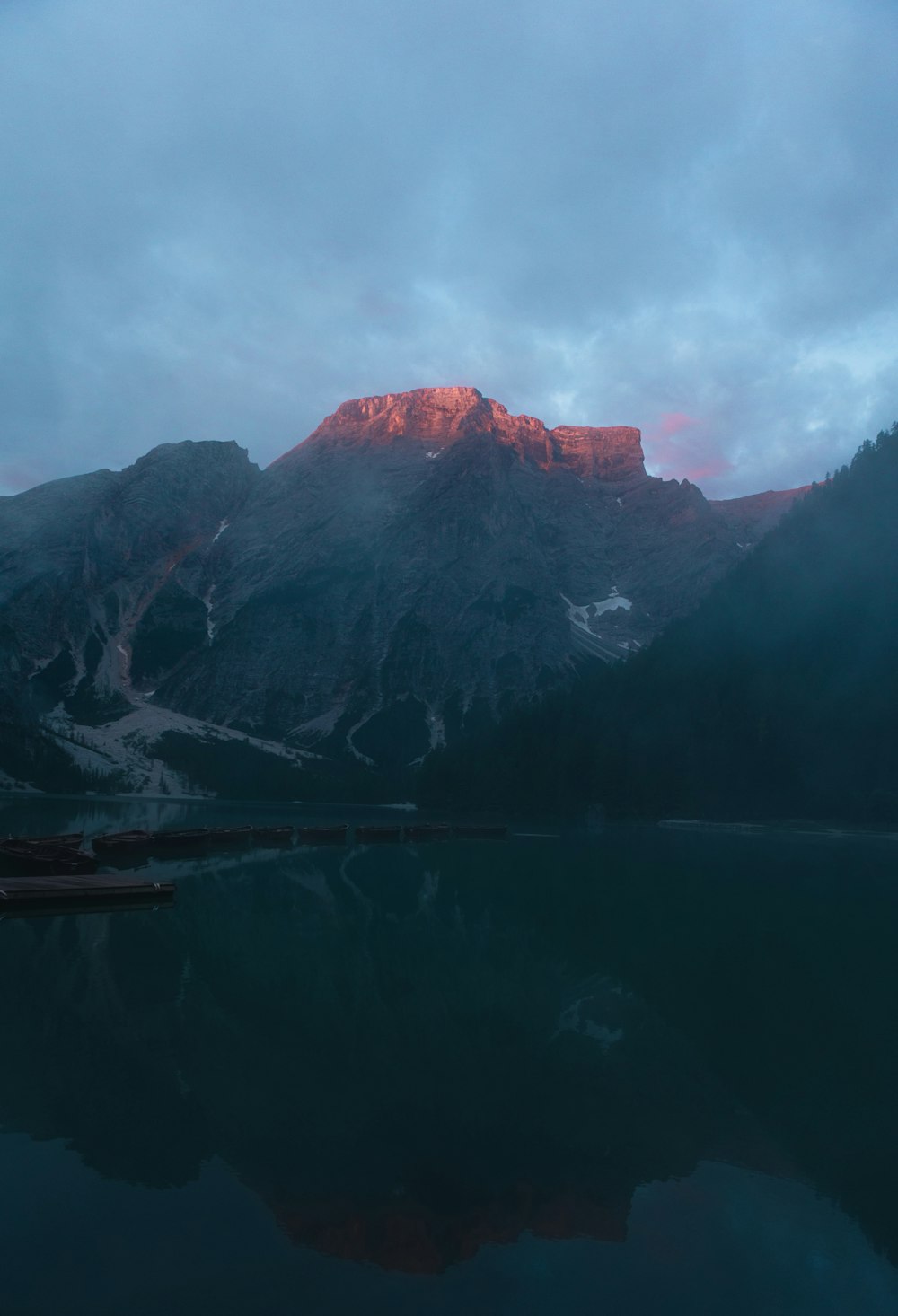 body of water near mountain during daytime