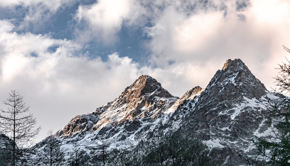 snow covered mountain under cloudy sky during daytime