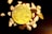 A physical representation of a Bitcoin sits among scattered small, smooth stones on a dark surface. The Bitcoin is prominently placed in the center, showcasing its intricate design and golden color.
