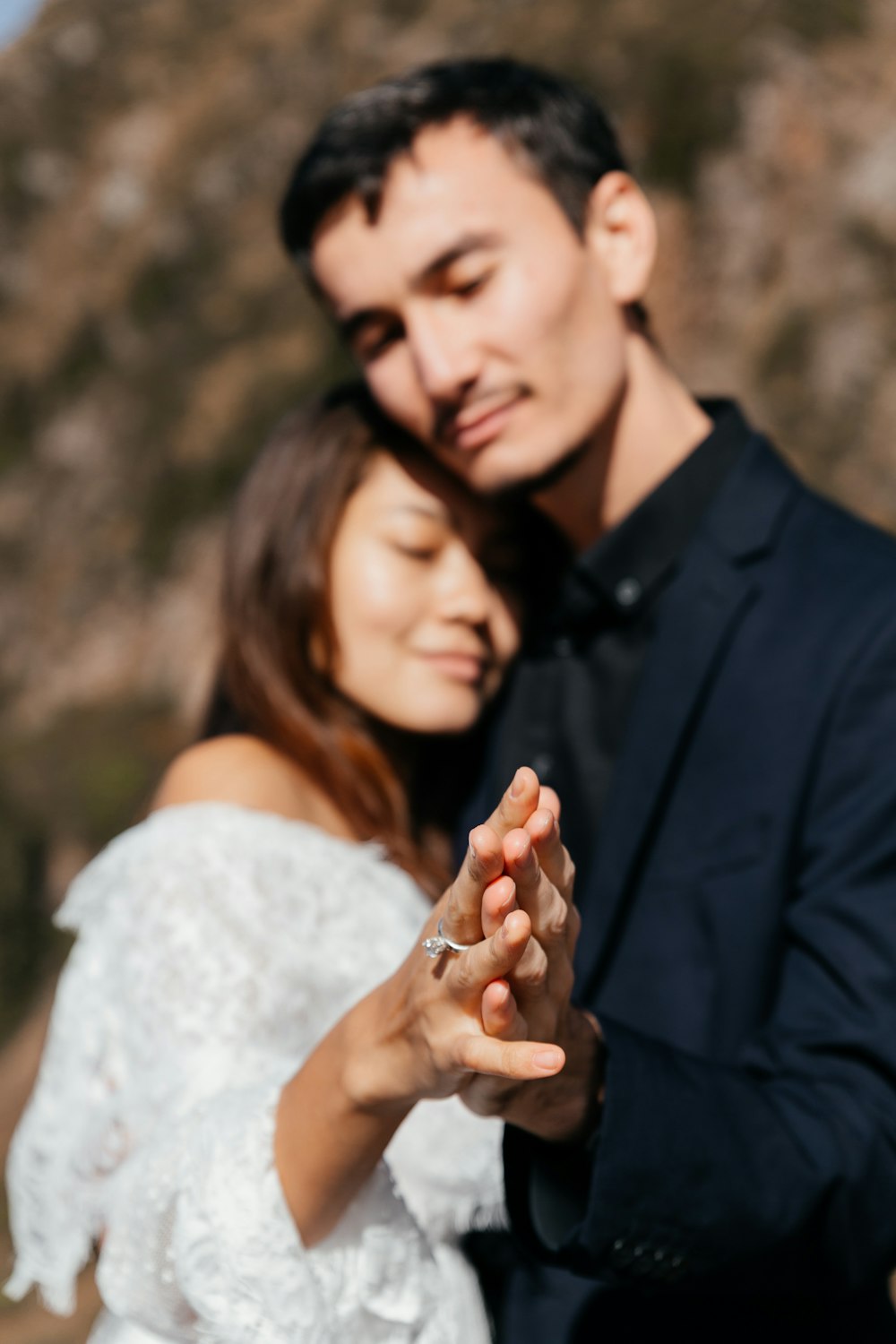 man in black suit jacket holding womans hand