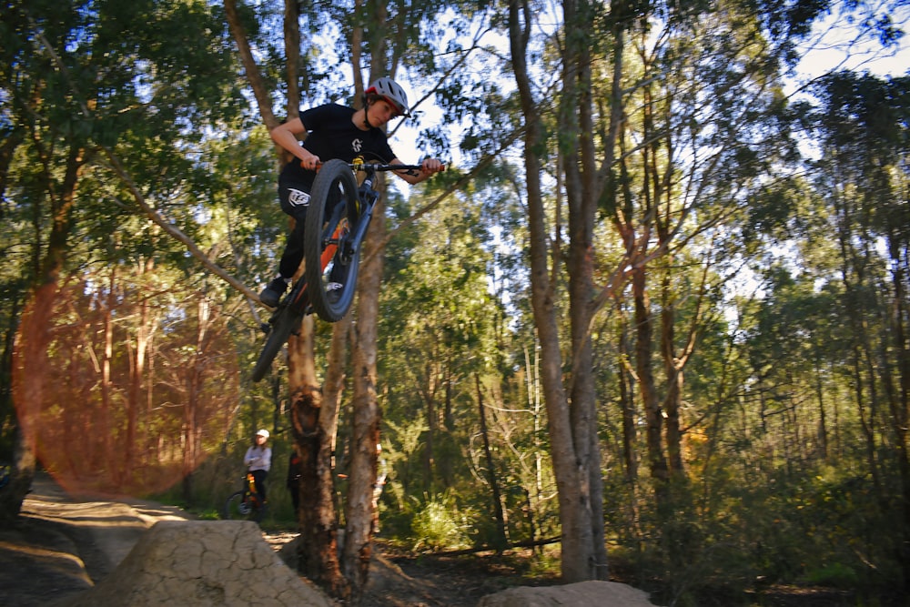 man riding bicycle on forest during daytime