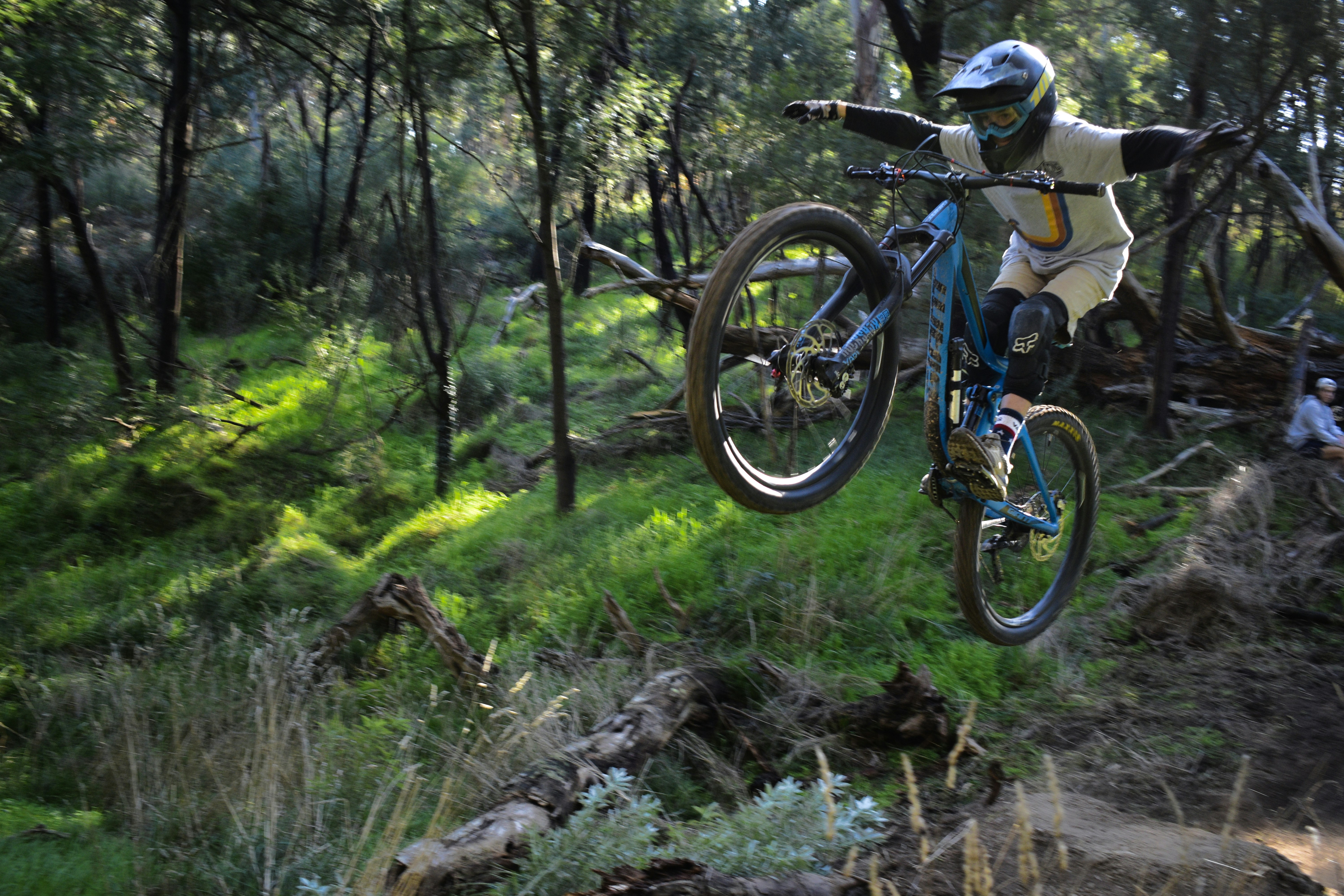 man in blue shirt riding bicycle on forest during daytime