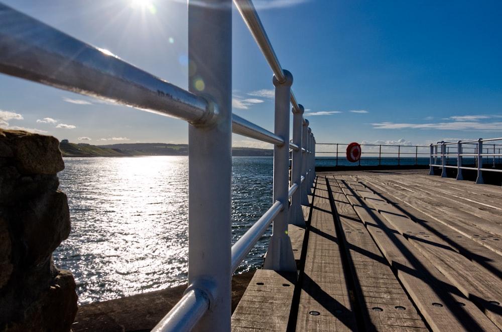 white metal railings near body of water during daytime