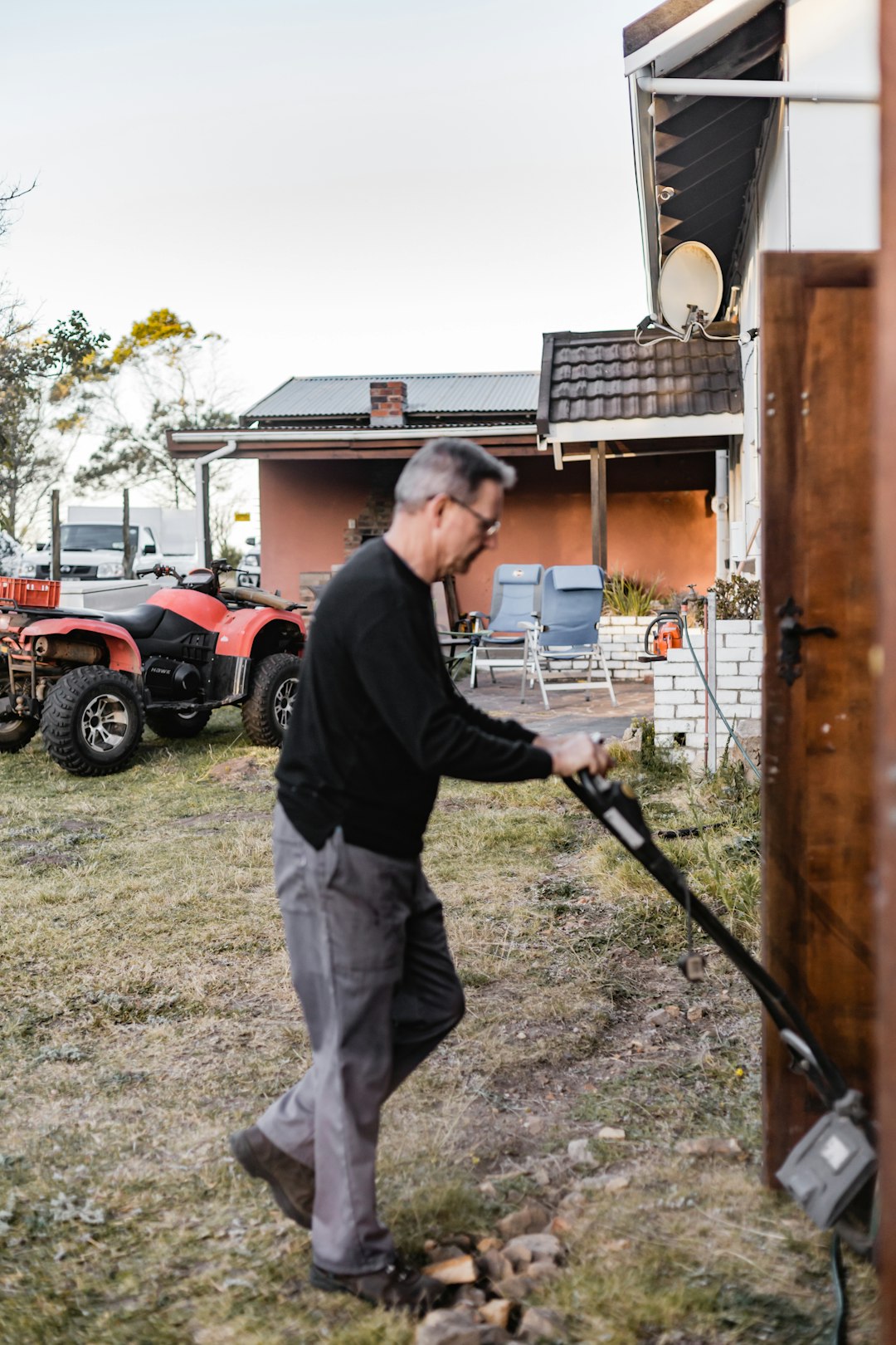 man in black long sleeve shirt and gray pants holding black stick