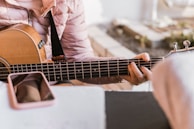 Guitarist playing an acoustic guitar used as a guide for AI-powered arrangements.