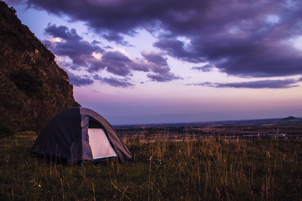 gray tent on brown grass field under gray clouds