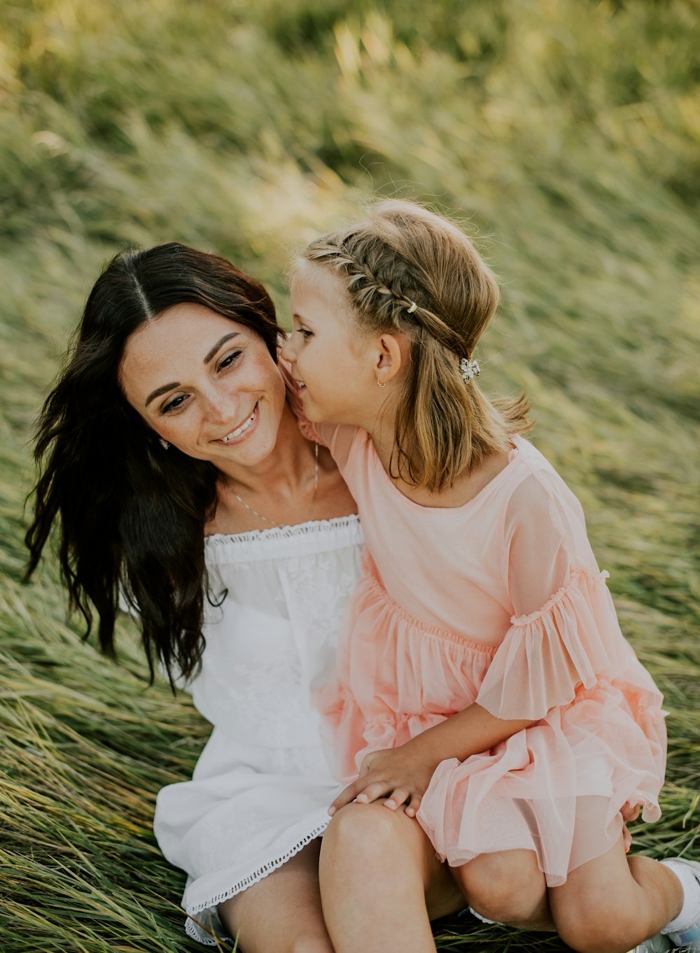 woman in white dress hugging woman in pink dress