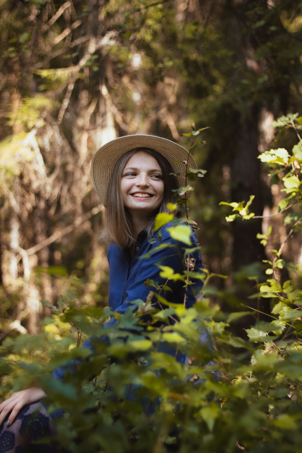 woman in blue jacket and brown hat standing on green grass field during daytime