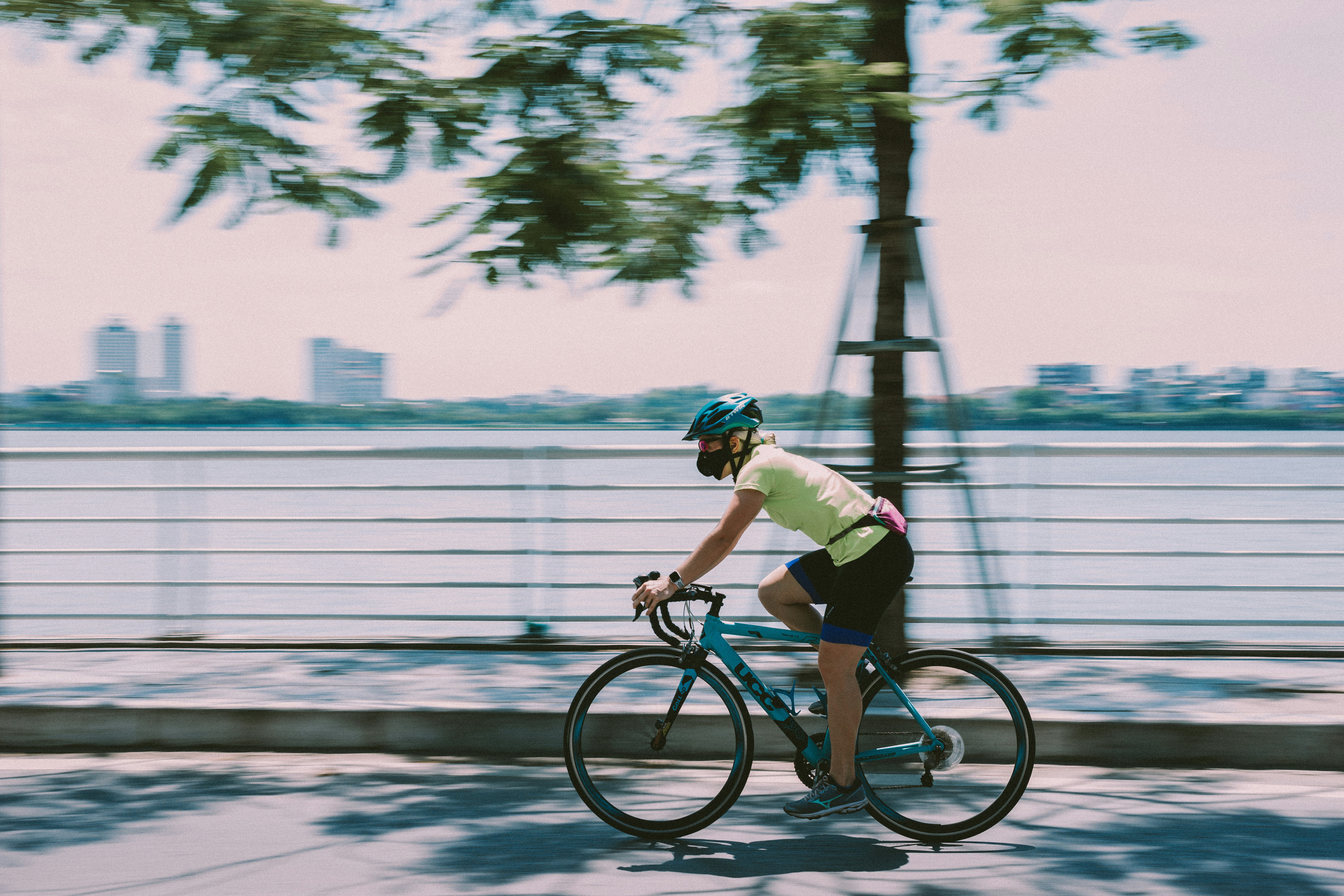 man in green shirt riding bicycle on road during daytime