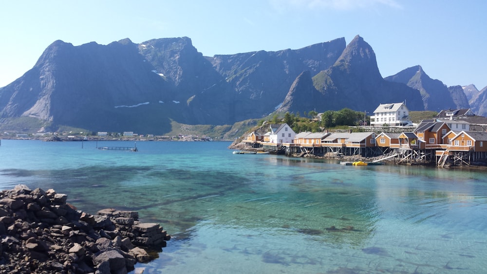 white and brown boat on sea near mountain during daytime