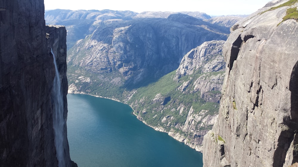 green and gray mountain beside body of water during daytime