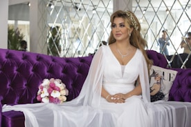 woman in white dress sitting on purple couch