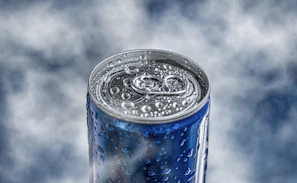 Close-up of a chilled Aquatonic energy drink can with condensation droplets, set against a navy background.