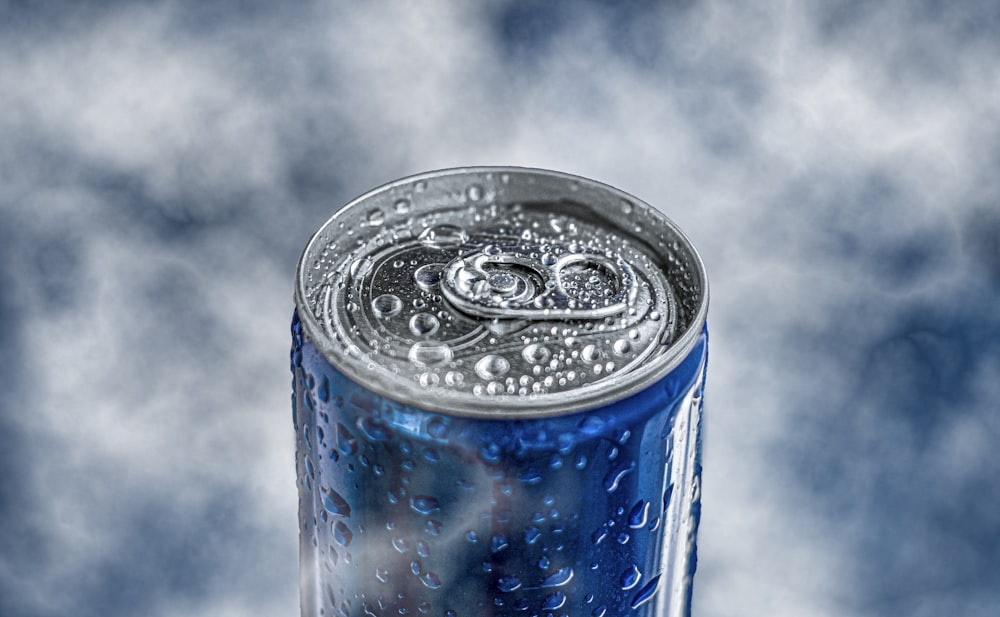 blue and silver can with water droplets