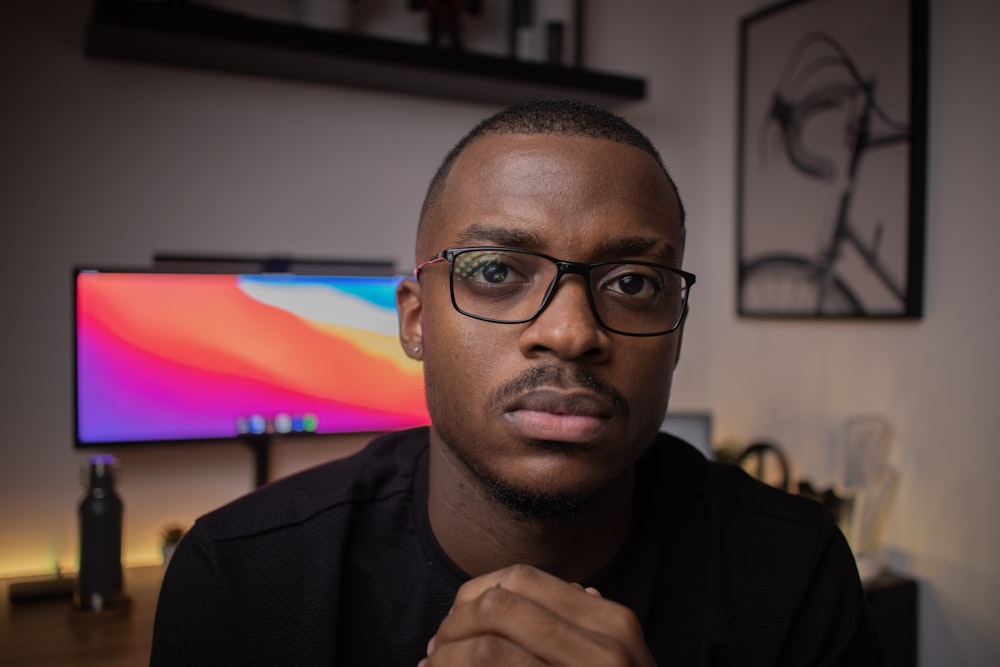 man in black framed eyeglasses and black shirt