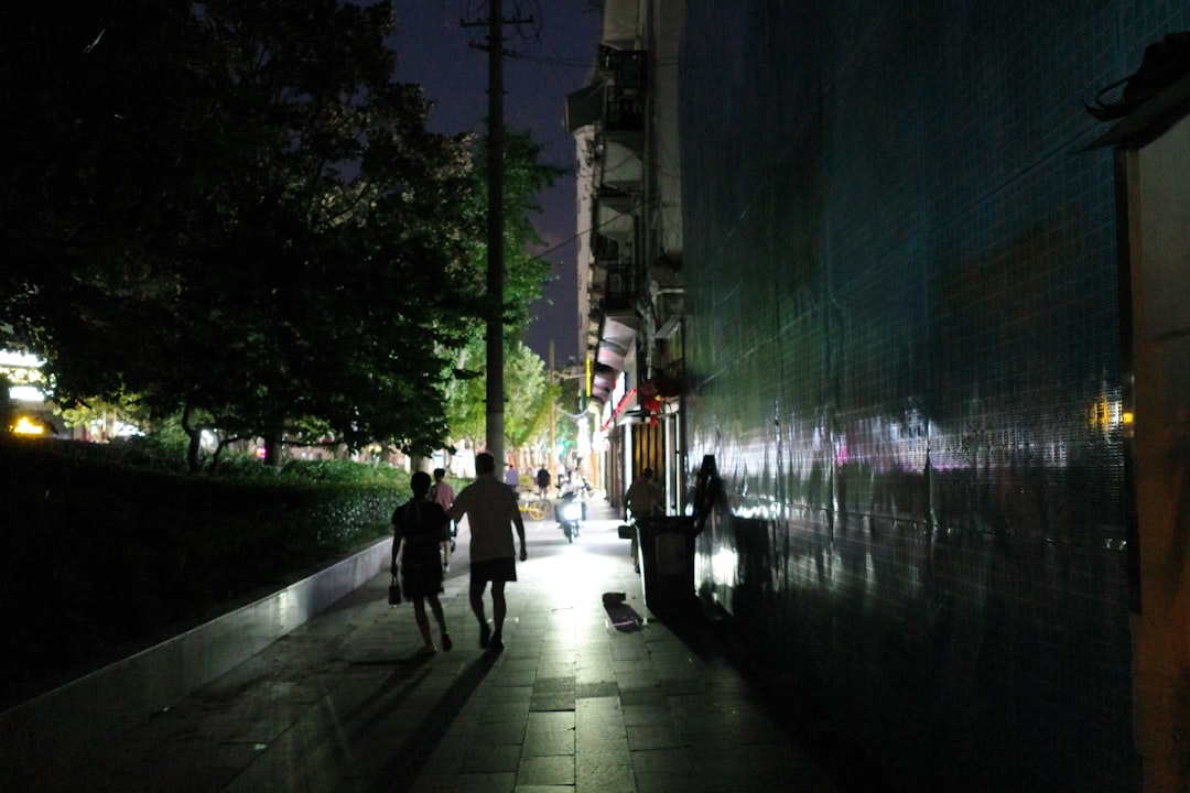 people walking on sidewalk during night time