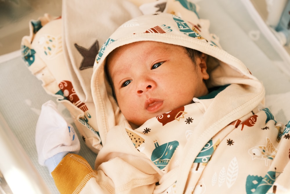 baby in white and brown hoodie