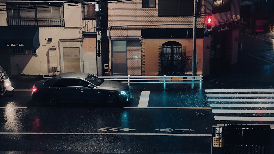 black car parked beside brown building during night time