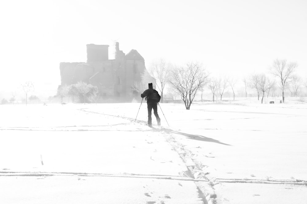 Person, die tagsüber auf einem schneebedeckten Feld spazieren geht