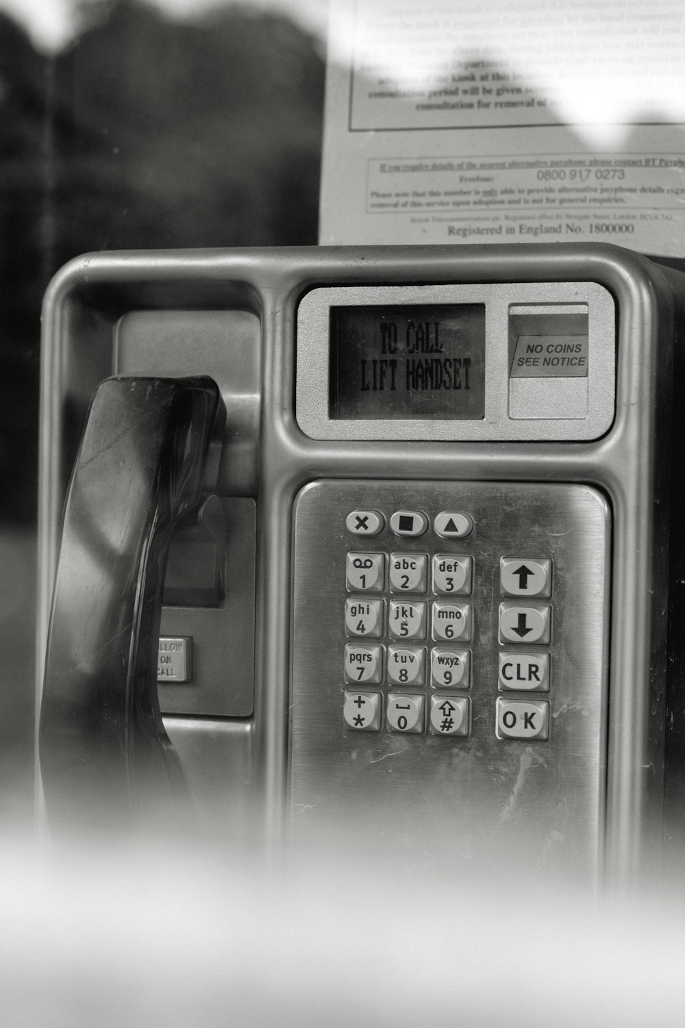 grayscale photo of telephone on table