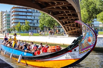people riding on red and blue boat during daytime
