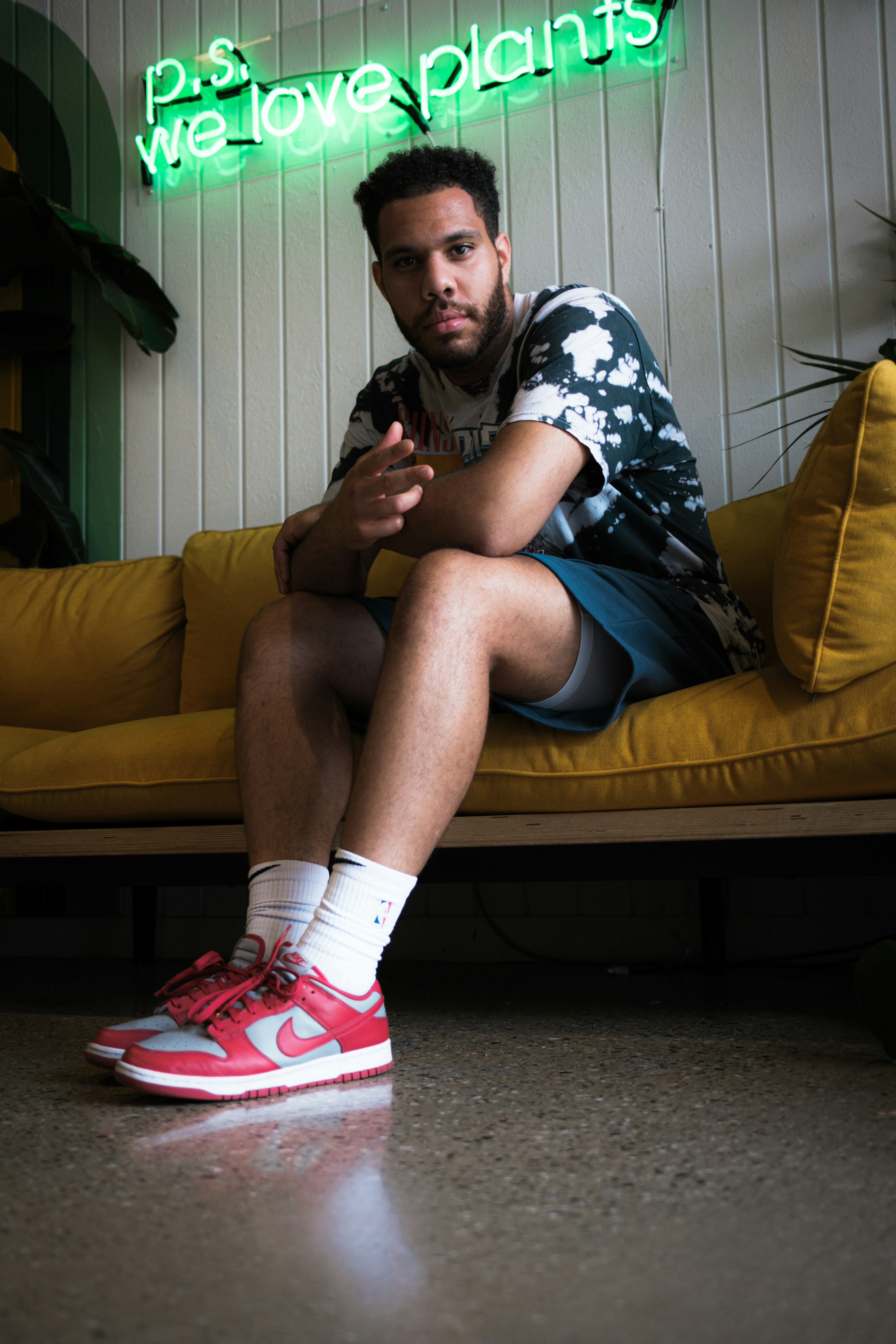 femme en short en jean bleu assise sur un canapé en cuir jaune