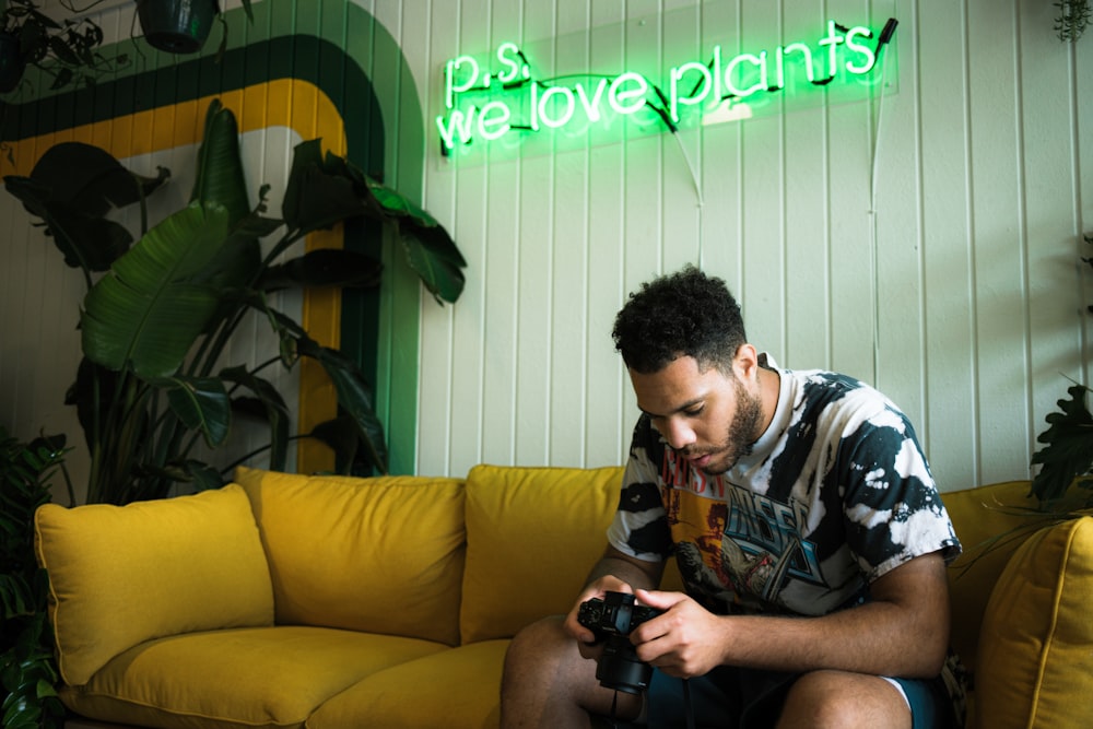 man in black and white camouflage shirt sitting on brown couch