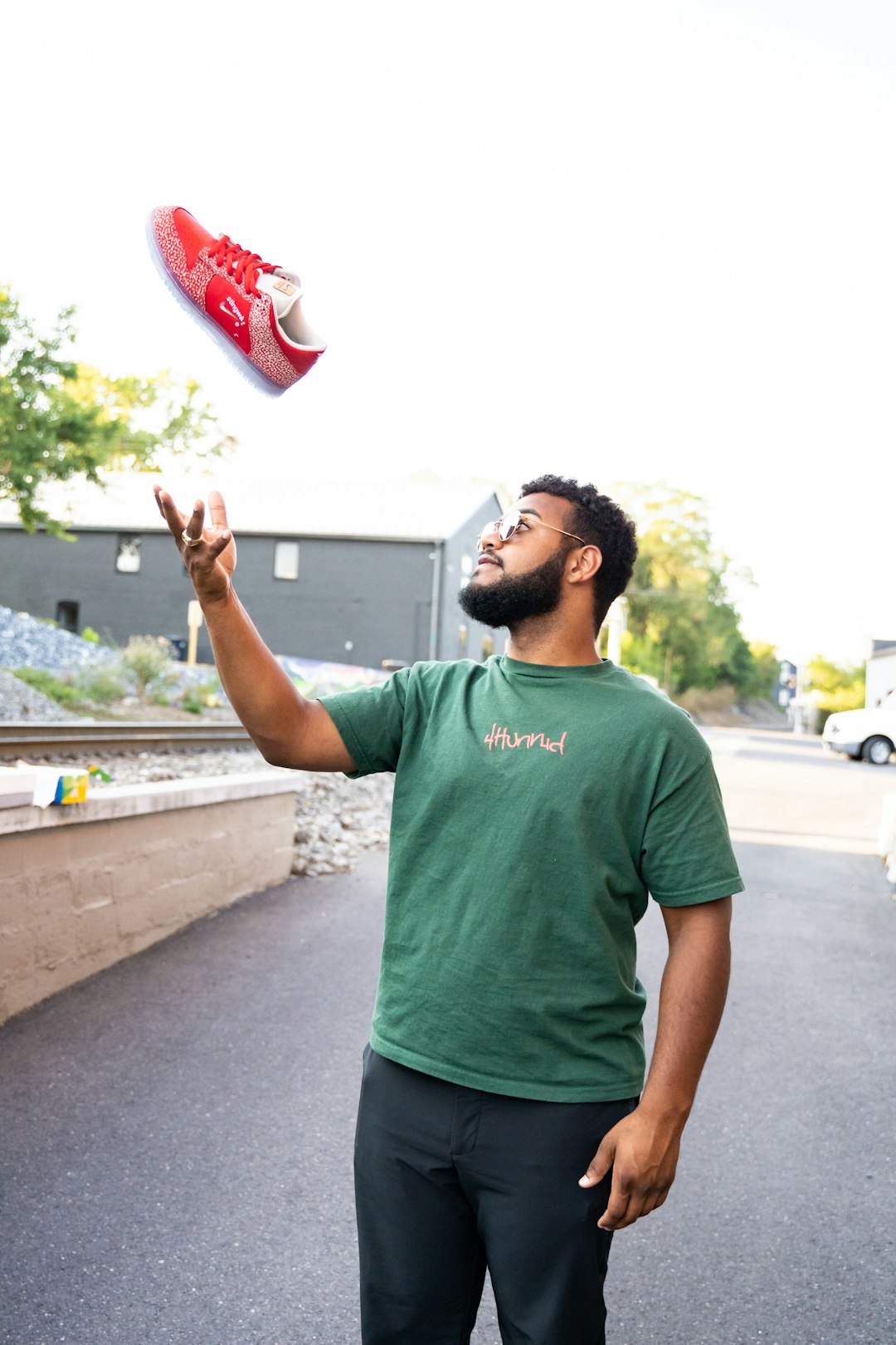 man in green crew neck t-shirt raising his right hand