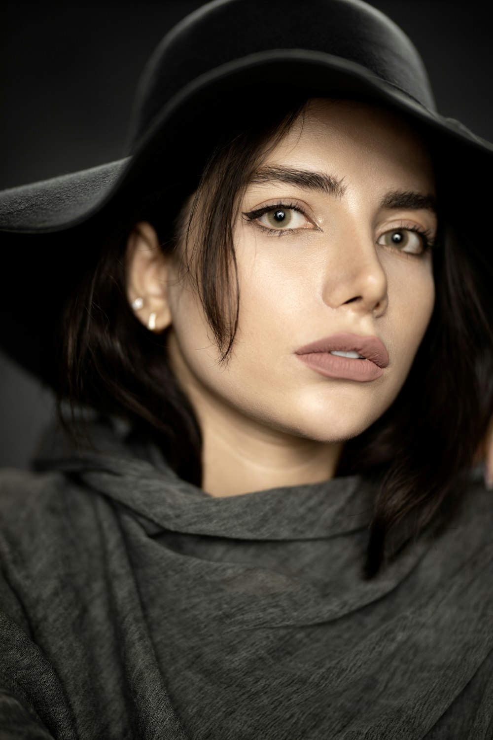 woman in gray hoodie wearing black hat