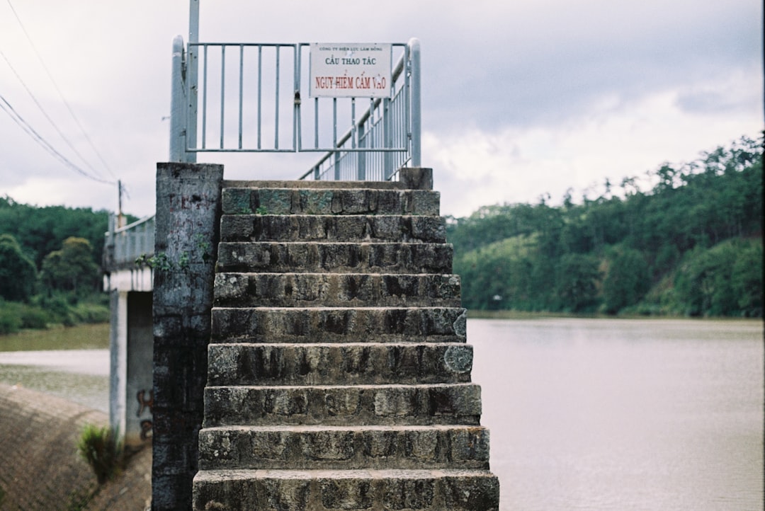 gray concrete staircase near body of water during daytime