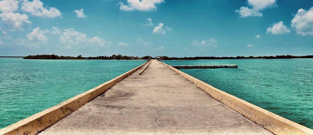 brown wooden dock on sea under blue sky during daytime