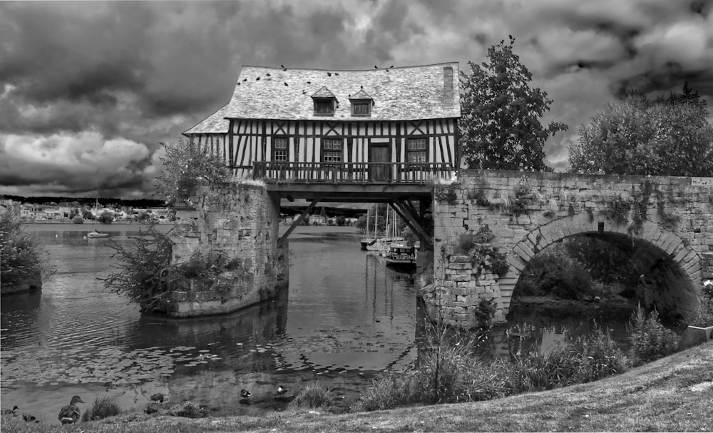 grayscale photo of house near river