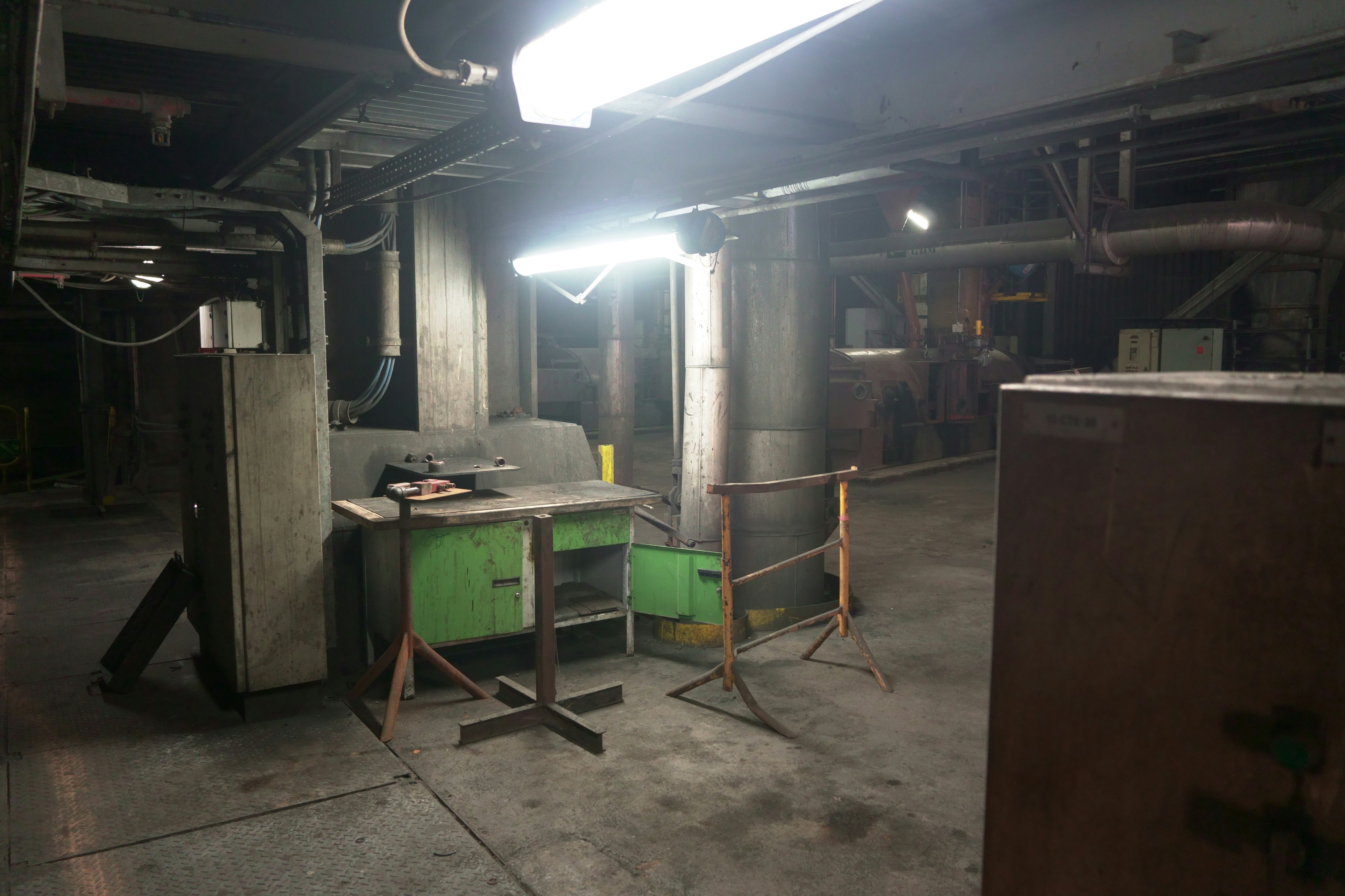 Industrial manufacturing workshop with bright overhead lighting, clean machinery, professional environment