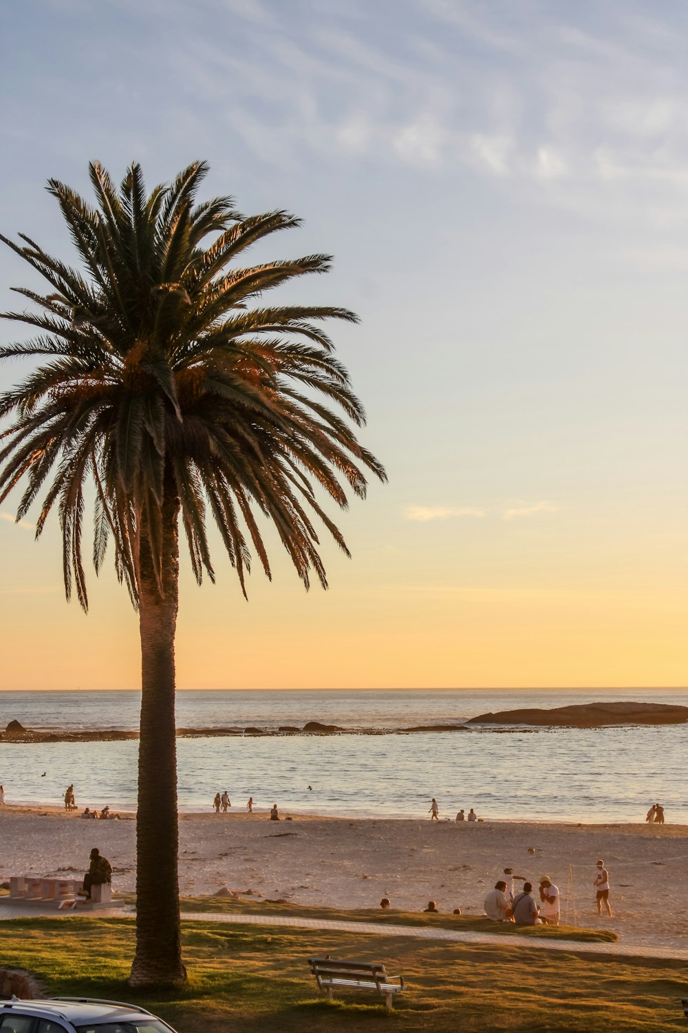 Gente en la playa durante la puesta de sol