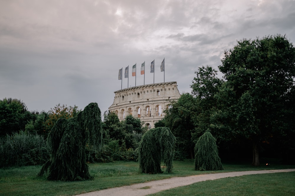 brown concrete building near green trees under cloudy sky during daytime