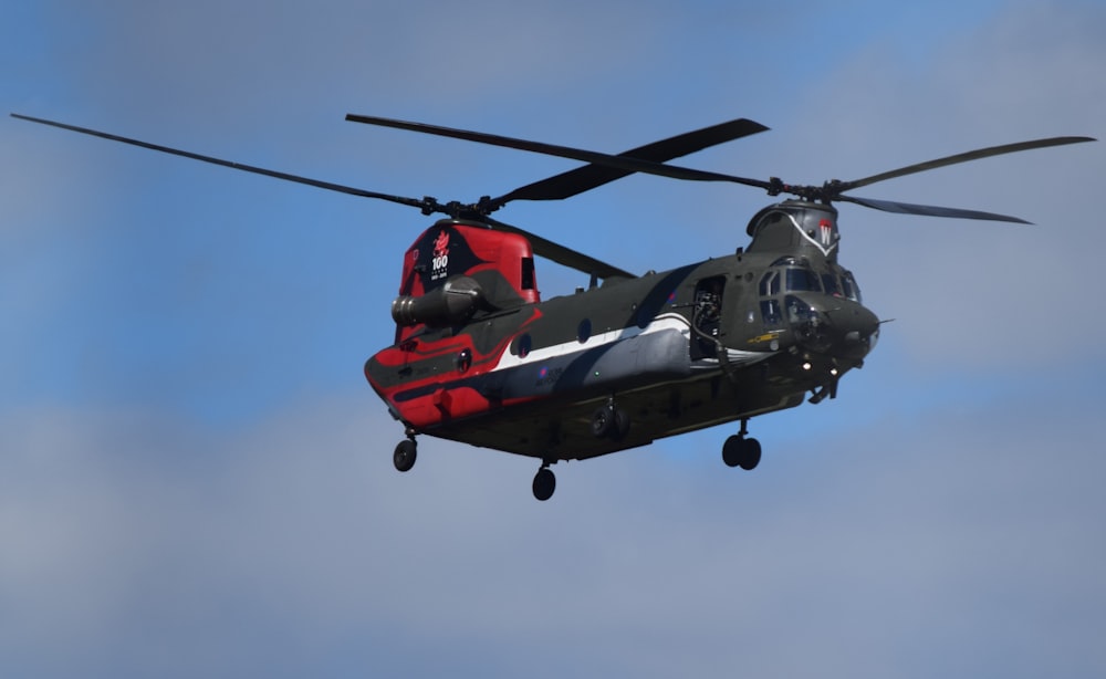 red and black helicopter flying in the sky
