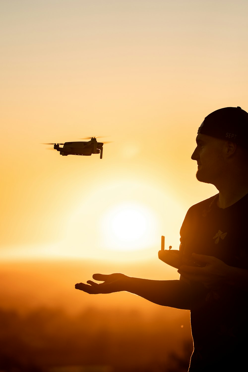 silhouette of man holding drone