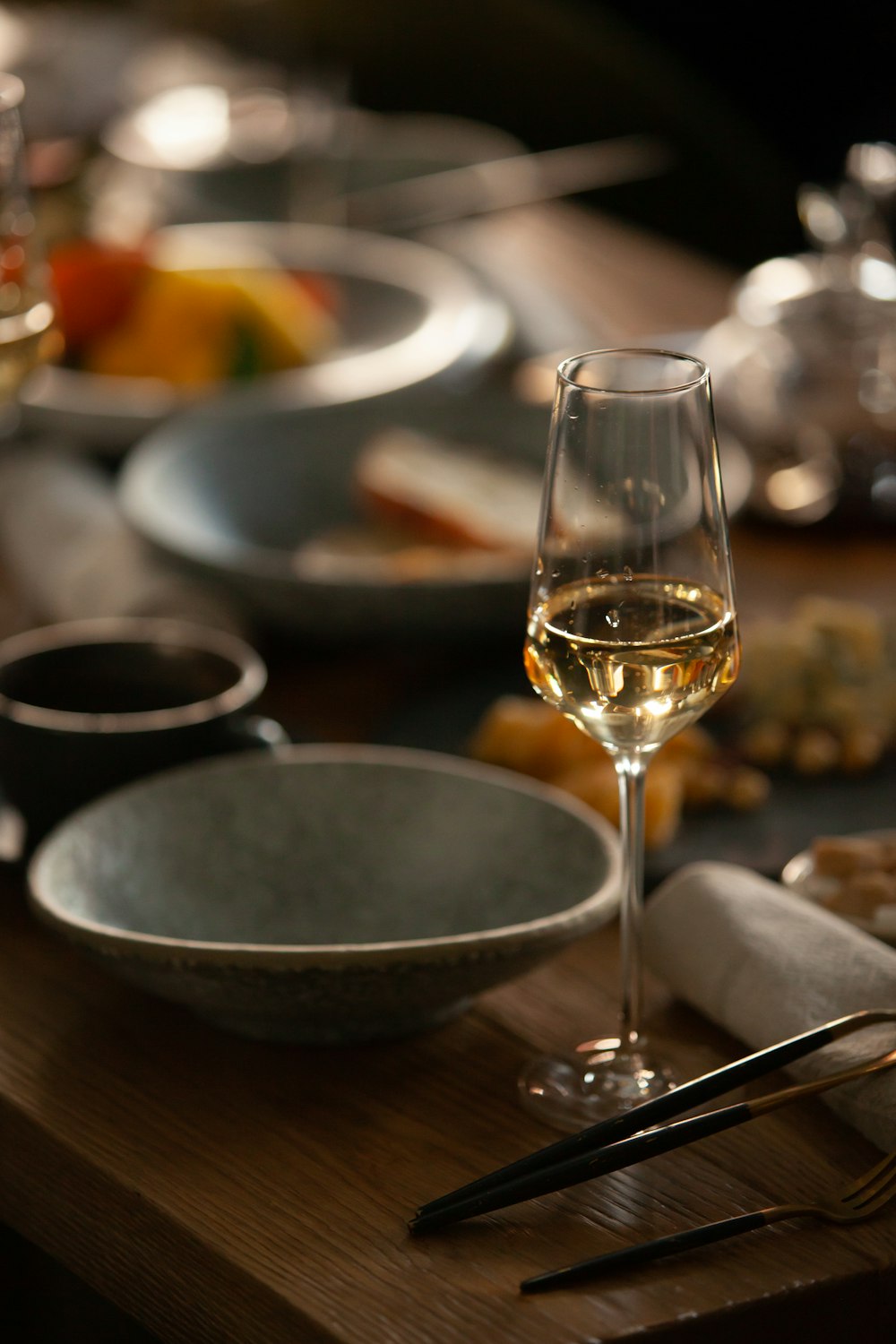 clear wine glass beside gray ceramic bowl