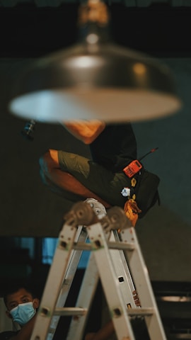 man in black t-shirt and brown shorts sitting on chair