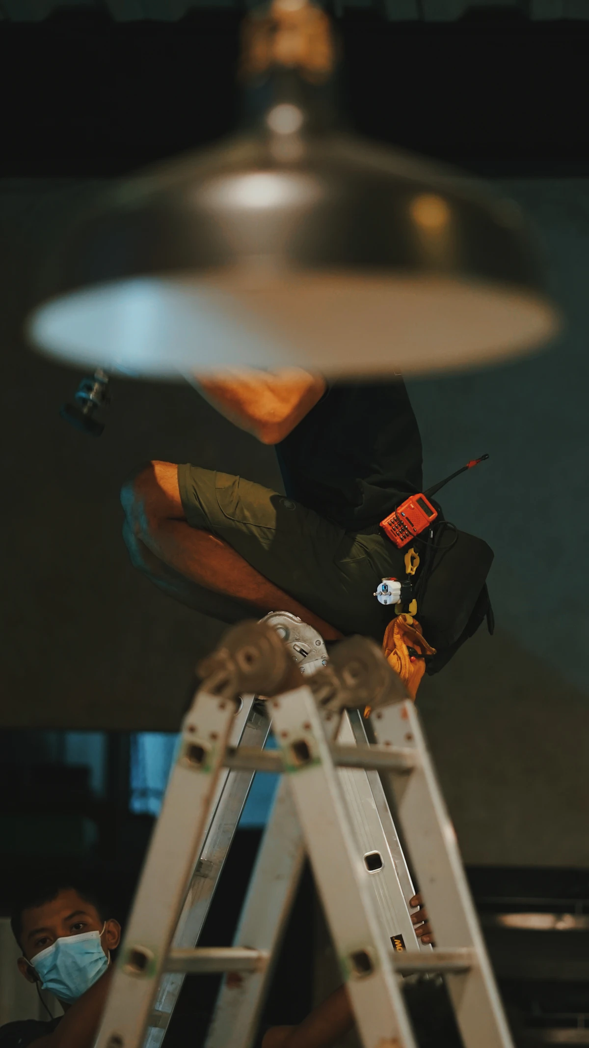 An electrician installing a light fixture