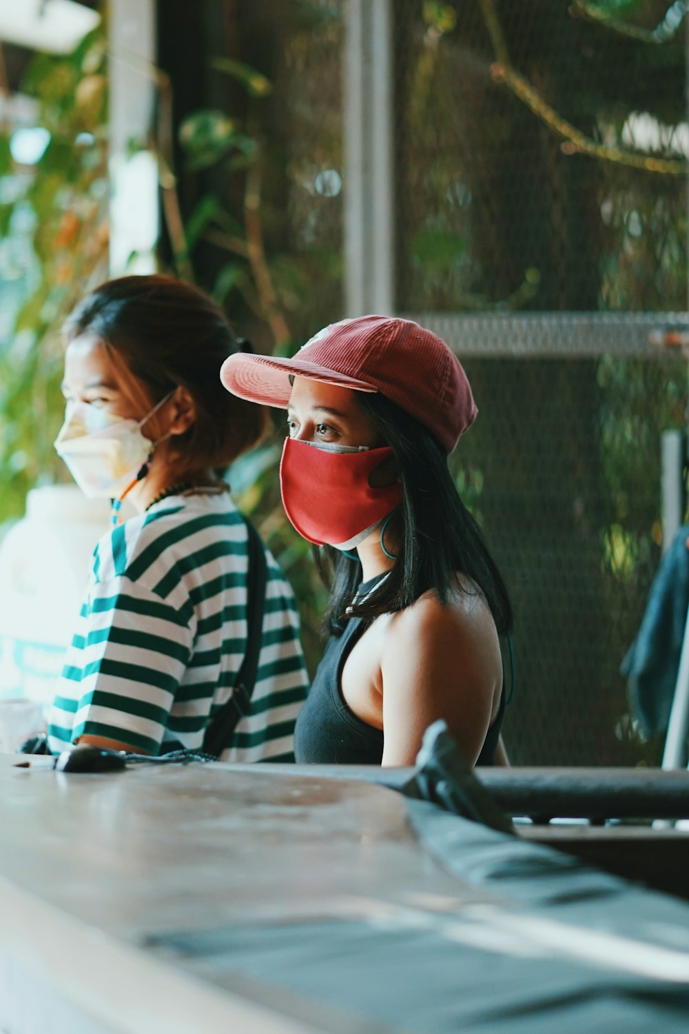 woman in white and black stripe tank top wearing red cap