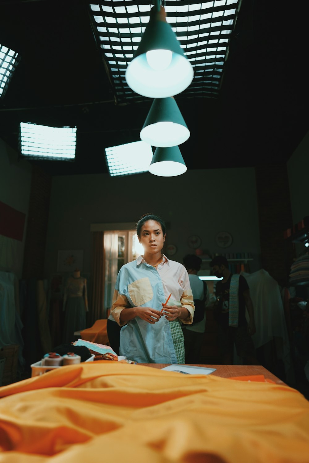 woman in white long sleeve shirt standing beside brown wooden table