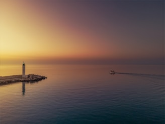 A warm glowing lighthouse shining over a calm sea at dusk, symbolizing guidance and hope.