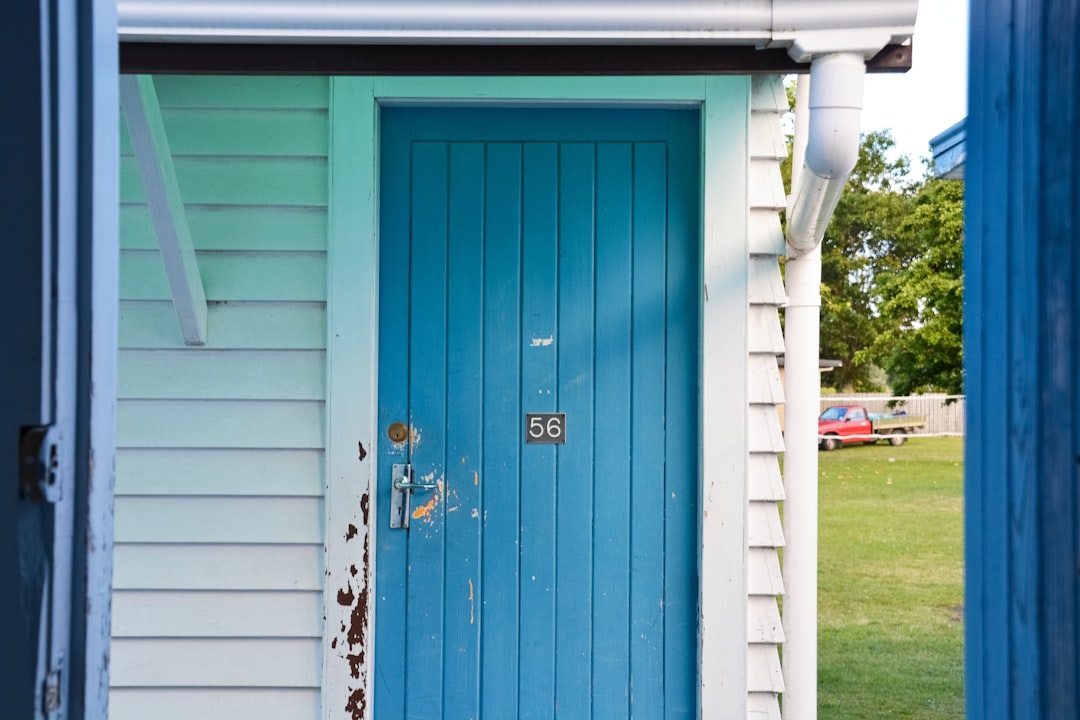blue wooden door with white steel door lever