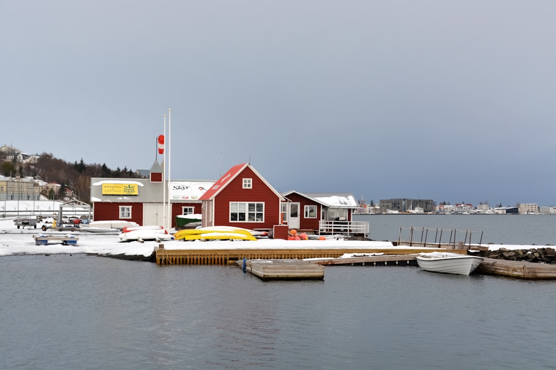 white and red house near body of water during daytime