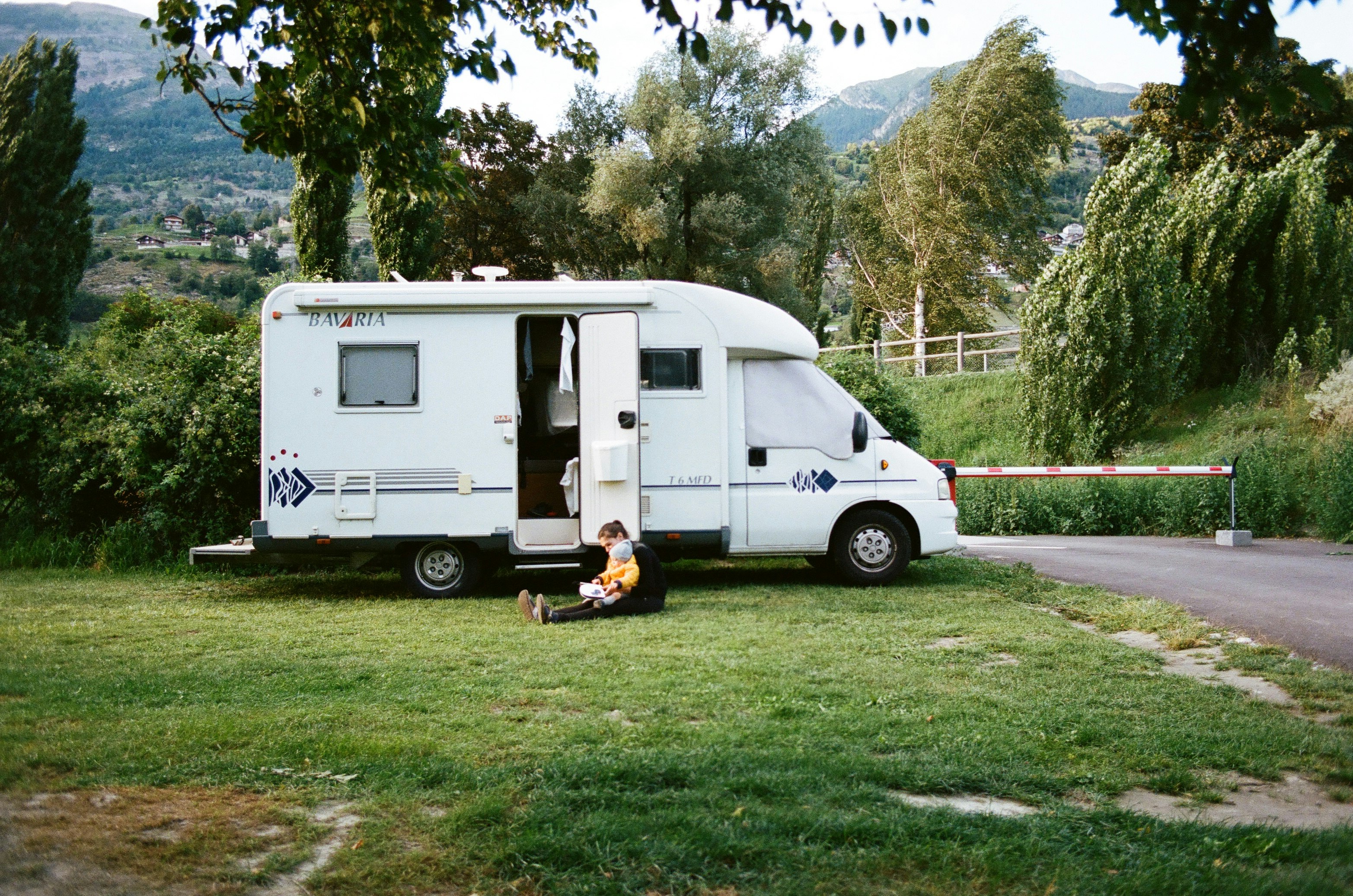 white rv trailer on green grass field during daytime